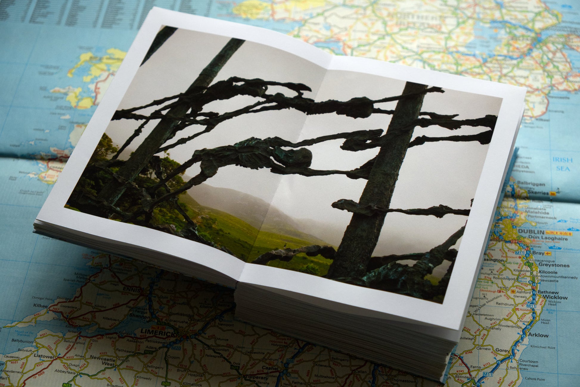 product photograph of handmade photography book on map of Ireland showing interior spread of photograph of famine memorial in Connemara